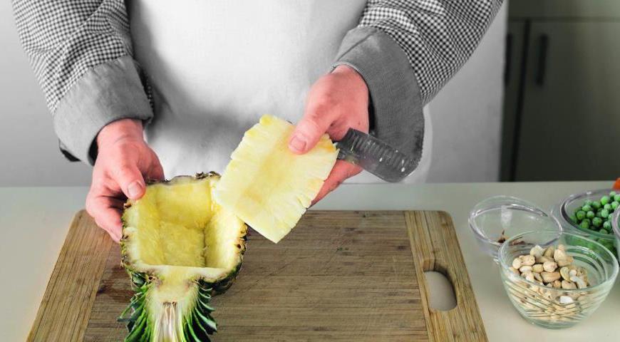 Разогрейте духовку до 180 °C. Разрежьте ананас на две части, оставив верхушку. Аккуратно выньте мякоть, сохраняя форму кожуры. Оберните листья фольгой, чтобы они не подгорели. Протрите внутреннюю часть бумажными полотенцами и запекайте 7 минут, чтобы немного усилить аромат.