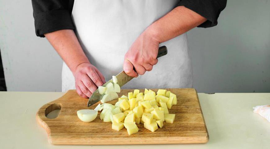 Очистите картофель и лук. Лук нарежьте тонкими четвертинками колец, картофель разрежьте на 6–8 частей. Положите их в кастрюлю, залейте 1,7 литра кипящей воды, добавьте немного соли и доведите до кипения. Варите на среднем огне под крышкой около 28 минут до мягкости картофеля.
