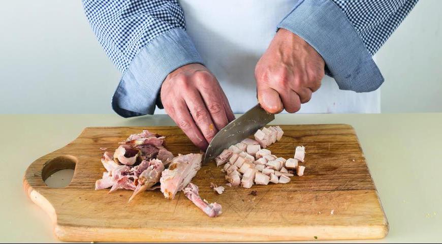 Снимите кожу с копченой птицы, отделите мясо от кости и нарежьте его средними кусочками.