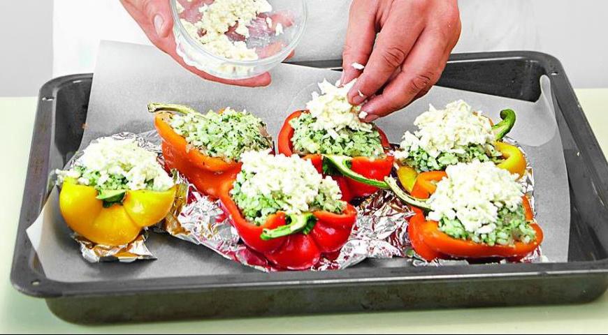 Разрежьте перцы на две части, аккуратно удаляя семена и перегородки. Наполните половинки перцев подготовленной начинкой и посыпьте тертым сыром.