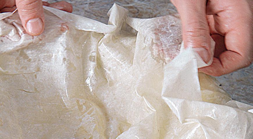 Растопите оставшееся масло и смажьте им форму для запекания. Выложите шесть слоев теста фило, каждый из которых смазывайте маслом. Аккуратно прижмите края к стенкам формы, оставив немного свободного пространства сверху для формирования верхней части пирога.