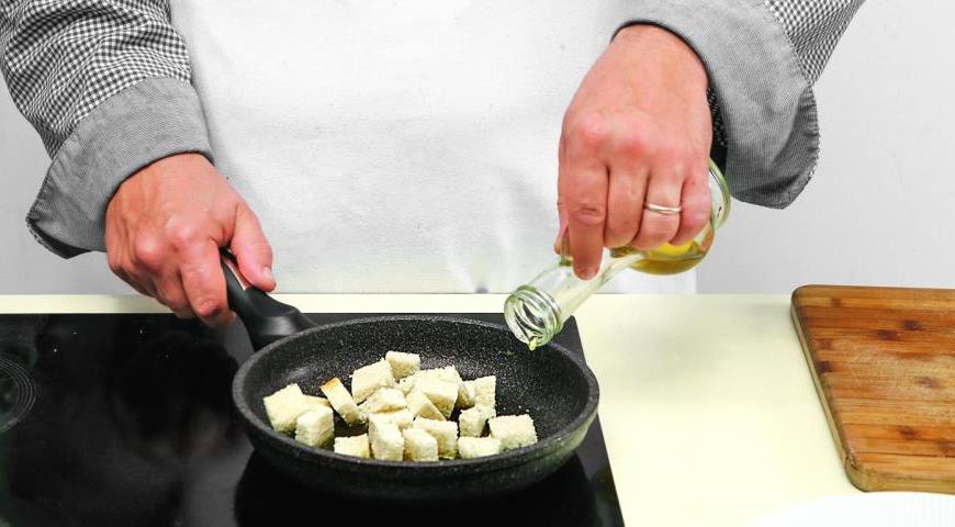 У хлеба удалите корку, нарежьте мякиш кубиками и быстро обжарьте до золотистой корочки в той сковороде, где жарился бекон, добавив немного оливкового масла.