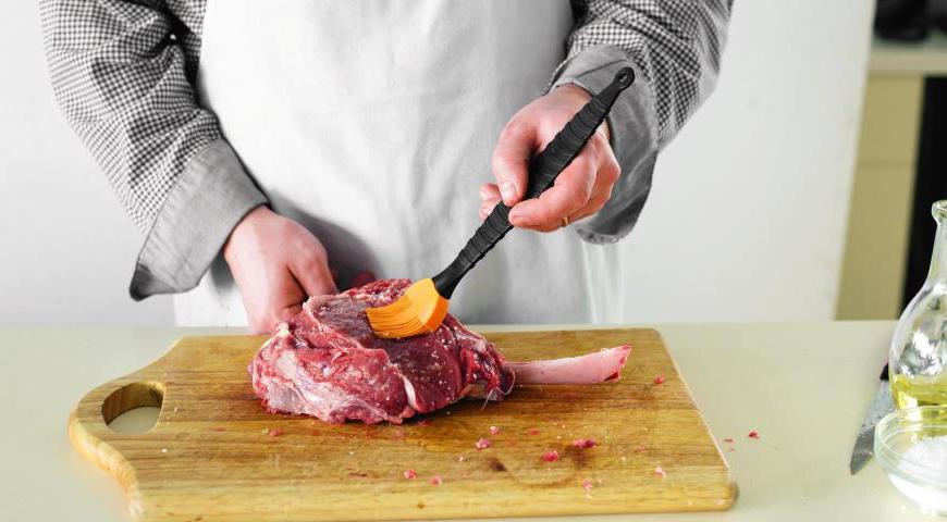 Приступайте к маринованию. Посолите и поперчите мясо с обеих сторон. Нанесите оливковое масло на поверхность антрекота, используя кулинарную кисть. Это поможет образовать золотистую корочку во время жарки.