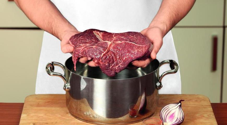 Уложите мясо в большую кастрюлю с толстым дном. Добавьте подготовленные овощи и белое сухое вино. Залейте кипящей водой так, чтобы она покрывала мясо наполовину. Доведите смесь до кипения и уберите образующуюся пену.