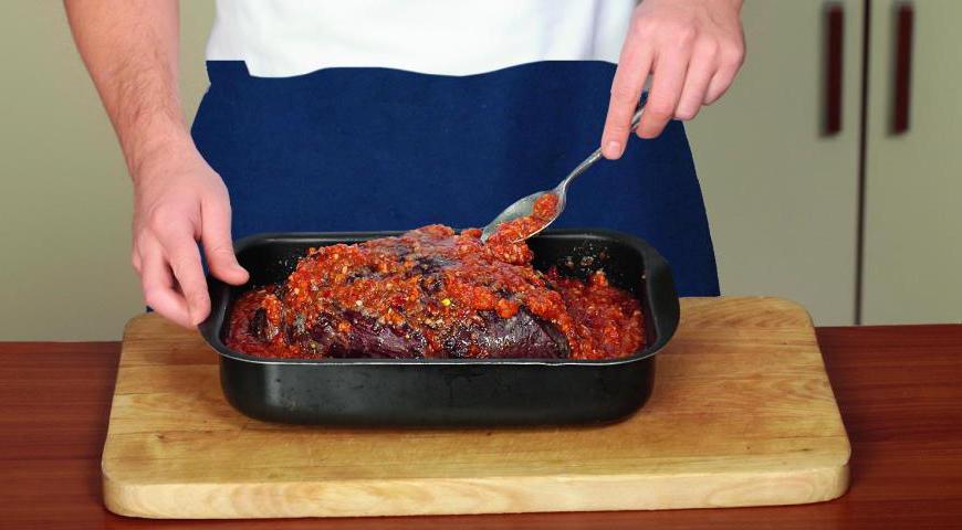После того как мясо будет готово, аккуратно выложите его в форму с томатным соусом. Полейте соусом со всех сторон. Накройте форму плотной фольгой или крышкой. Уменьшите температуру духовки до 165 °C и продолжайте запекать в течение часа, чтобы мясо стало мягким и сочным.