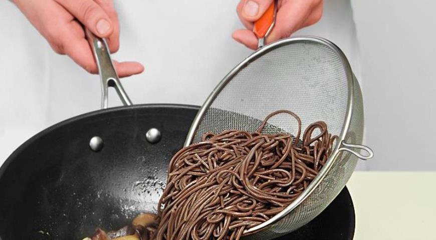 Включите лапшу в вок, полейте кунжутным маслом и прогрейте еще 30 секунд. Подавайте с мелко нарезанным шнитт-луком, чтобы добавить свежести и яркости.