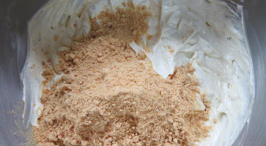 Постепенно, тонкой струйкой, введите остывший сироп в масло, продолжая взбивать до однородности. В конце добавьте 3 столовые ложки коньяка и снова взбейте. В одну треть крема добавьте молотый грильяж и хорошо перемешайте.