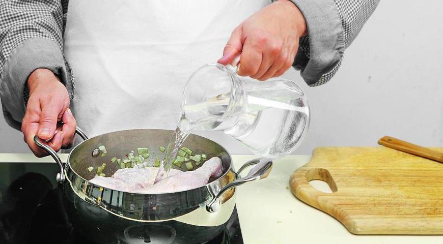 Добавьте в кастрюлю перловку, затем положите куриные окорочка, влейте 1,6 л воды и поставьте на огонь. После закипания снимите пену, добавьте измельченные помидоры и орегано. Уменьшите огонь и варите примерно 45 минут. Проверьте готовность перловки – она должна быть почти мягкой.