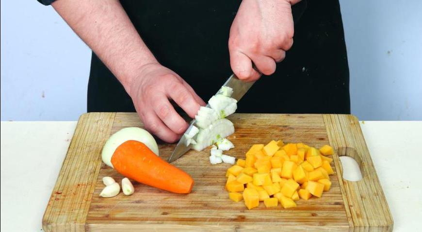 Очистите лук, чеснок и морковь. Нарежьте мякоть тыквы средними кубиками, а лук, сельдерей и морковь – мелкими кубиками. Чеснок порубите. Через час после начала варки добавьте овощи в кастрюлю и продолжайте варить ещё 35 минут, пока фасоль не станет мягкой.