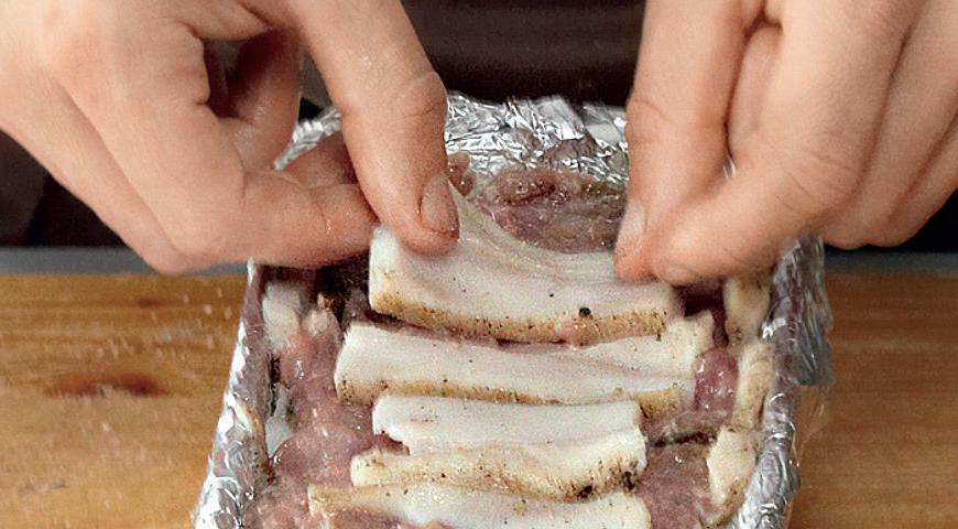 Прямоугольную форму для запекания посыпать солью и перцем. Тонко нарезать замороженное сало, выстелить дно и бока формы. Выложить фарш частями, пересыпая фундуком. Утрамбовать, накрыть ломтиками сала, завернуть форму в фольгу и запечь на водяной бане в разогретой до 170 °С духовке, 1,5 ч. Остудить, прижать прессом, поставить в холодильник на 24 ч. Подавать с тостами.