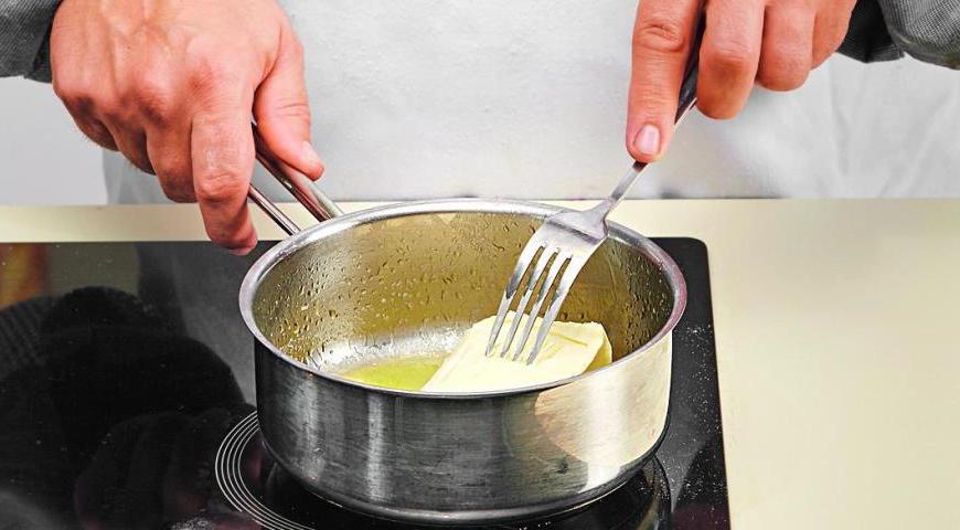 Смешайте измельченные мюсли с растопленным маслом и выложите в форму. Охладите 25 минут.
