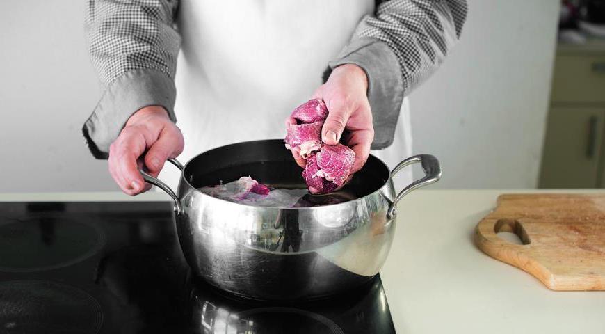 Поместите сырое мясо и кости в кастрюлю, залейте холодной водой и дайте постоять 30 минут. Промывайте, затем снова залейте 4 литра воды.