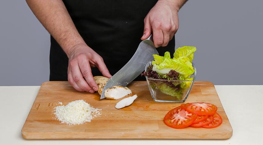 Подготовьте все ингредиенты: нарежьте курицу небольшими кубиками, помидоры - тонкими кружочками. Листья салата разорвите руками на произвольные части. Натрите сыр на крупной терке.