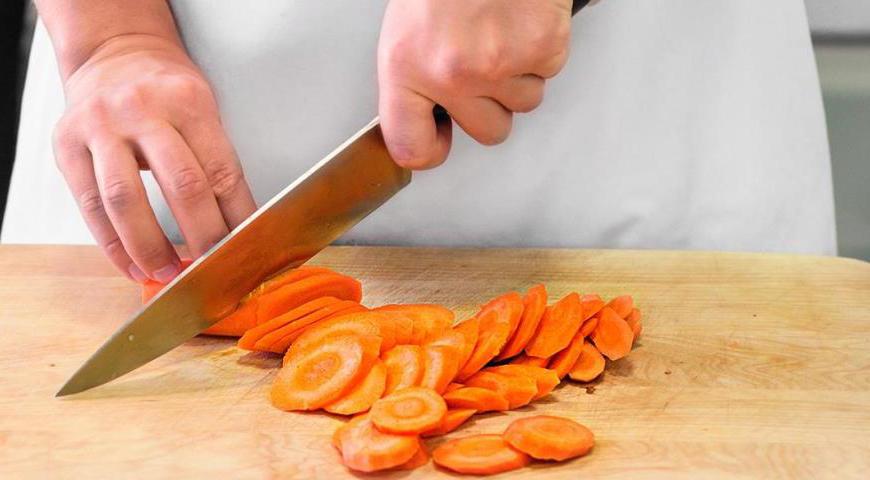 Очистите морковь и нарежьте ее тонкими ломтиками. Приготовьте смесь специй: растолките семена зиры и кориандра, затем добавьте их в казан. Также положите в бульон морковь и острую паприку. Продолжайте томить на медленном огне около 17 минут, чтобы специи раскрыли свой аромат.