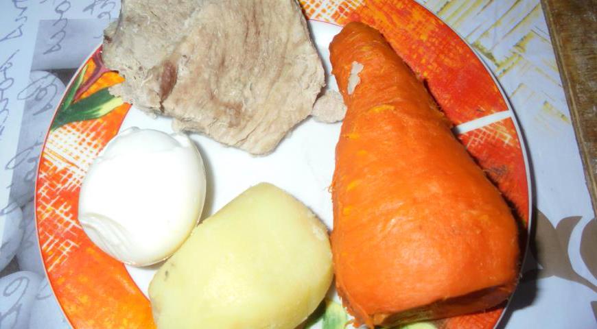 Отварите картофель, морковь и яйца до полной готовности. После остужения очистите их от кожуры и скорлупы соответственно. Свинину отварите в слегка подсоленной воде до мягкости.