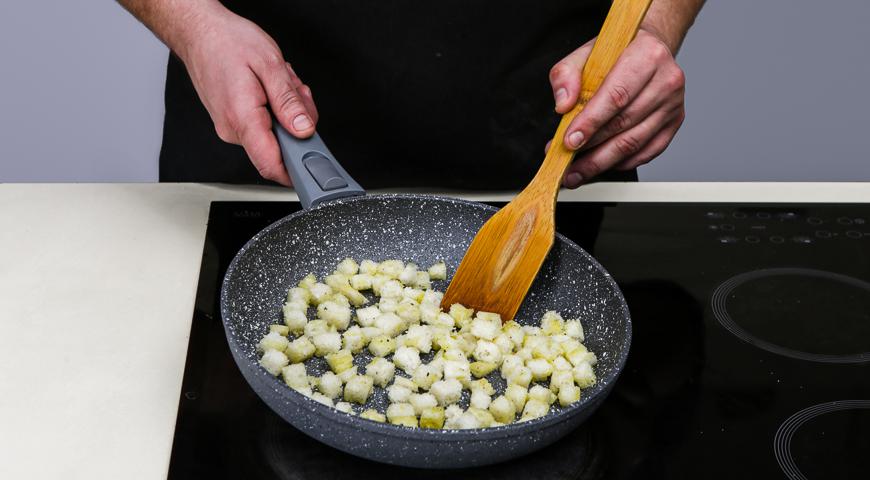 Срежьте корки с пшеничного хлеба и нарежьте его кубиками размером 1х1 см. В отдельной миске смешайте пропущенный через пресс чеснок, 2,5 столовые ложки оливкового масла и 1,5 столовой ложки воды или овощного/куриного бульона. Посолите и поперчите по вкусу. Добавьте кубики хлеба и хорошо перемешайте, чтобы все они были равномерно покрыты смесью. Выложите их на разогретую сухую сковороду и подсушивайте около 3 минут до легкой золотистости.
