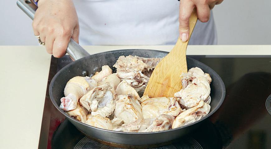 Разделите курицу на порционные куски. Нагрейте масло в глубокой сковороде и обжарьте мясо до золотистой корочки. Уменьшите огонь, накройте крышкой и готовьте до полуготовности.