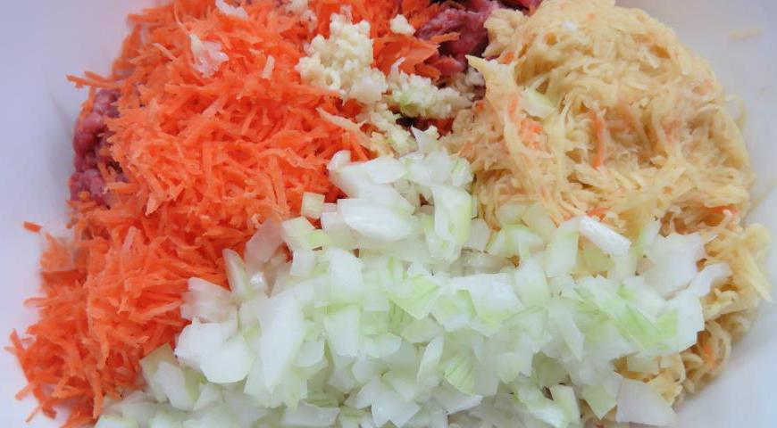 Лук очистите и нарежьте как можно мельче. Морковь и картофель натрите на мелкой терке. Добавьте выдавленный через пресс чеснок. Посолите и поперчите по вкусу.