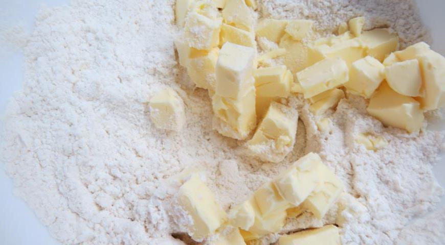 Положить в чашу нарезанное мелким кубиком сливочное масло, перемешать руками с мукой, пропуская между пальцев. Получившаяся масса должна быть похожа на пластилин.