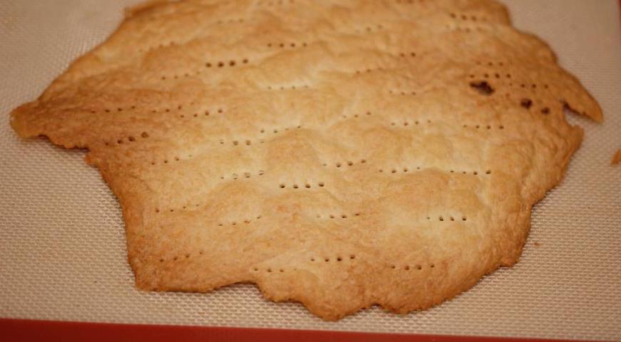 Разогрейте духовку до 200°C (при наличии функции конвекции её лучше включить). Раскатывайте тесто тонко, накалывайте вилкой и выпекайте на силиконовых ковриках или пергаменте до светло-золотистого цвета — около 7–10 минут.