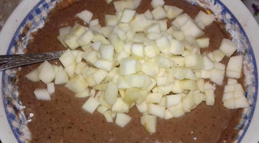 Яблоки очистите от кожуры и сердцевины, нарежьте мелкими кубиками. Грецкие орехи измельчите ножом или блендером. Добавьте оба ингредиента в тесто и аккуратно перемешайте.