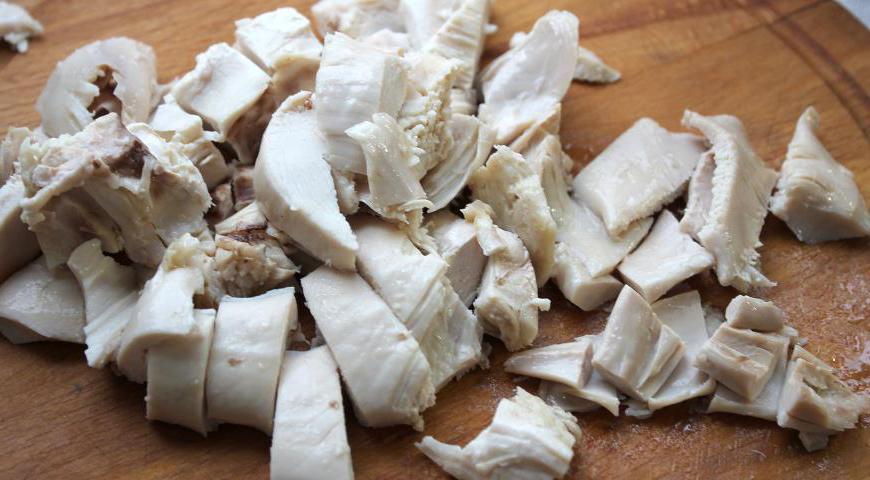 Готовое мясо птицы аккуратно отделите от костей и нарежьте кубиками. Раковые шейки или лангустины, у которых уже нет красивых хвостиков, также нарежьте маленькими кусочками.