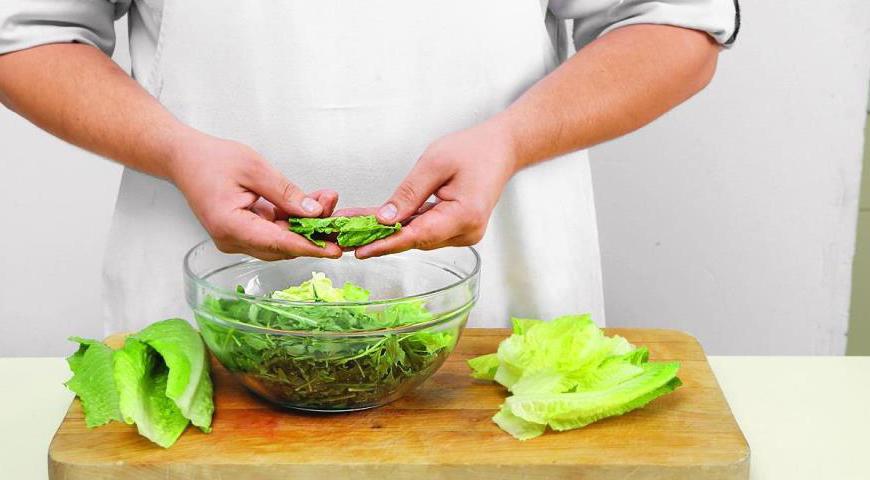 Вырежьте сердцевину из кочана романо и отложите для украшения. Листья нарвите крупными кусками руками.