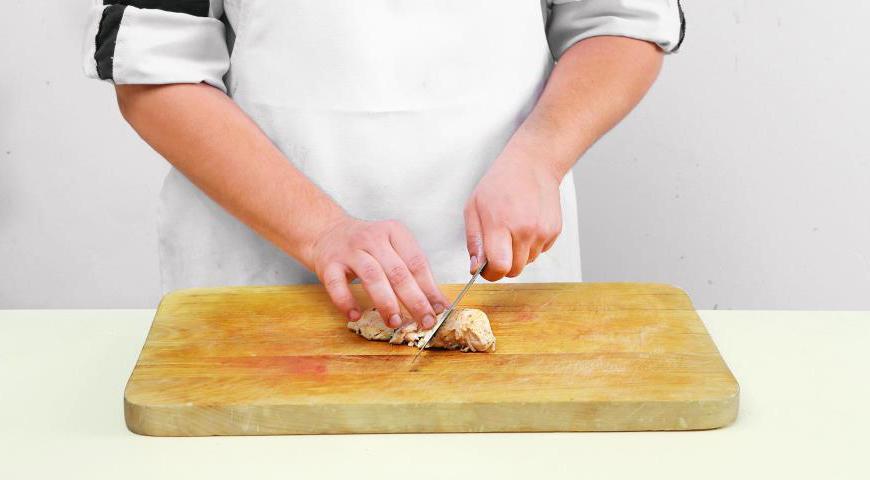 Нарежьте филе цыпленка тонкими кусками наискосок и выложите поверх салатных листьев. Посыпьте блюдо обжаренными кедровыми орехами и листьями кинзы. Украсьте листочками сердцевины салата романо.