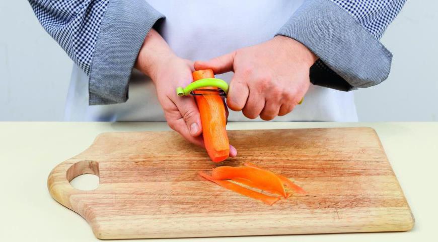 Очистите морковь и нарежьте ее тонкими лентами с помощью специального ножа. Разрежьте ленты на удобные для еды кусочки.