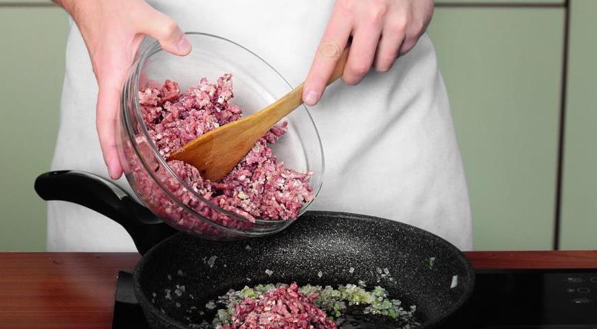 Добавьте мясной фарш к овощам, жарьте на сильном огне, разбивая комки вилкой или деревянной ложкой, пока весь фарш не станет равномерно коричневым.