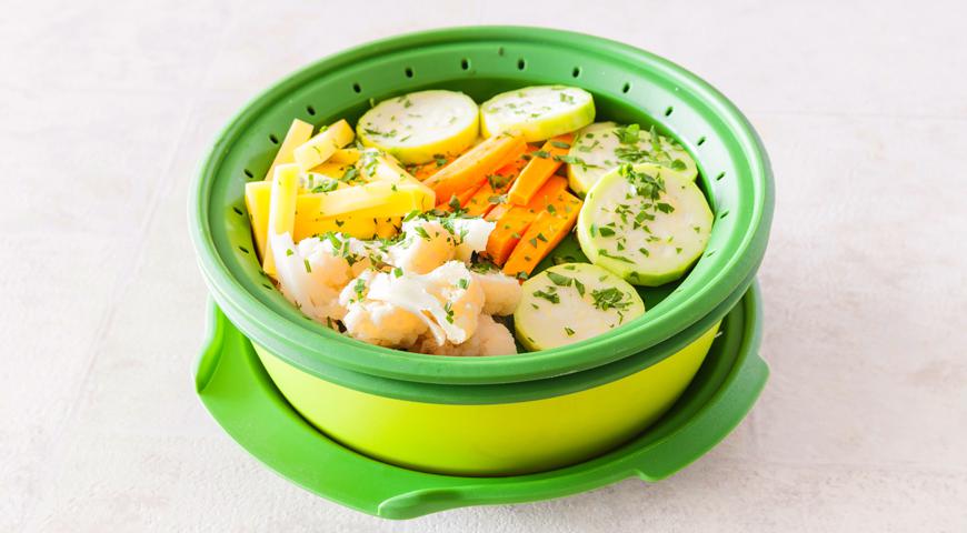 Картофель и морковь очистите и нарежьте тонкими брусочками. Цветную капусту разделите на небольшие соцветия, кабачок помойте и нарежьте кружками. Свежую мяту ополосните, просушите и мелко порубите. В емкость для пароварки налейте 300 мл воды.