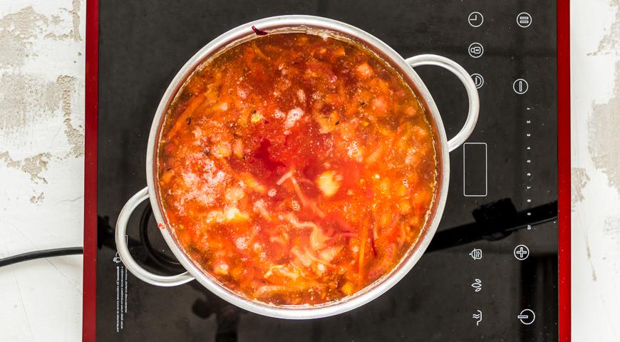 В сковороду с овощами добавьте помидоры, соль, перец по вкусу, закройте крышкой и тушите еще 22 минуты. Затем переложите тушеные овощи в кастрюлю с картофелем и капустой. Добавьте лавровый лист. Увеличьте огонь, доведите до кипения и аккуратно снимите образовавшуюся пену.