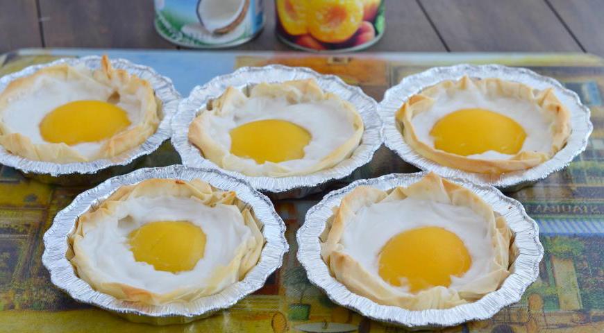 Разогрейте духовку до 180 °C. Поставьте формы с десертом внутрь и выпекайте около 25–30 минут, пока тесто не станет золотистым и хрустящим. После выпечки немного остудите десерт перед извлечением из формочек.