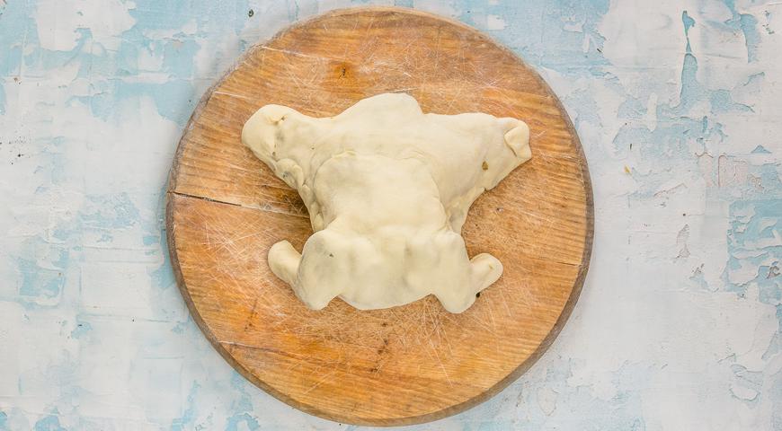 Аккуратно защипните края теста, формируя форму птицы. Лишнее тесто аккуратно обрежьте. Смажьте верх слегка взбитым яйцом. Повторите то же самое со второй половиной. Поставьте противень в духовку, разогретую до 200 °C, и запекайте 1 час 15 минут, накрыв фольгой. За 10 минут до окончания выпекания фольгу уберите, чтобы образовалась румяная корочка.