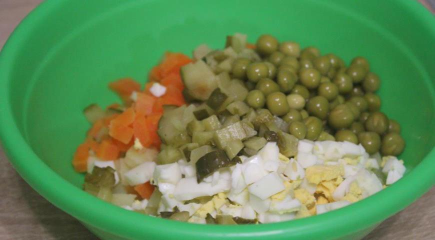 Картофель, морковь, яйцо и маринованный огурец нарезать небольшими кубиками. Добавить консервированный зеленый горошек.