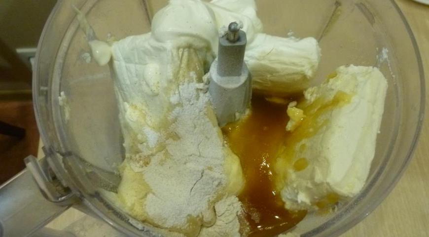 Разогрейте духовку до 175°C. В чашу комбайна положите творог, сметану, яйца, ваниль и мед. Измельчите до полностью однородной массы без комочков.