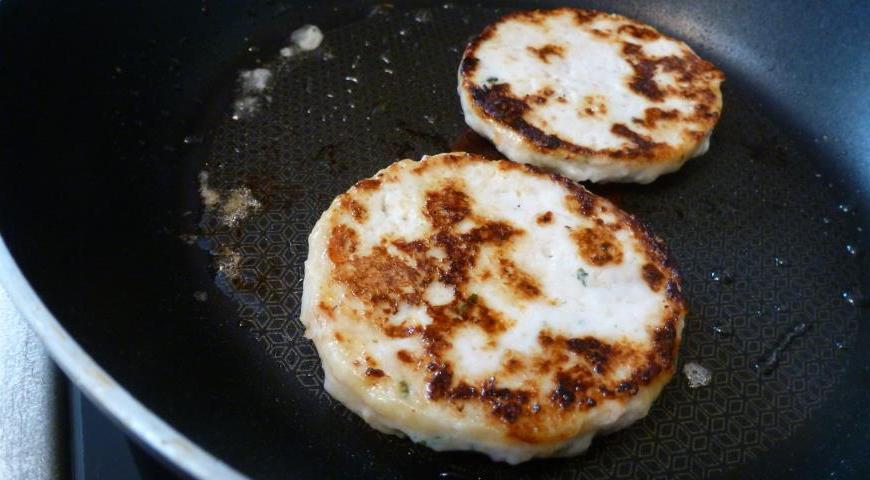 Для начала подготовим куриную начинку. Смешаем измельченную курятину с репчатым луком и яичным белком до однородности. Тщательно вымешиваем массу и формируем котлеты с помощью кулинарного кольца. Обжариваем их на сковороде до золотистой корочки.