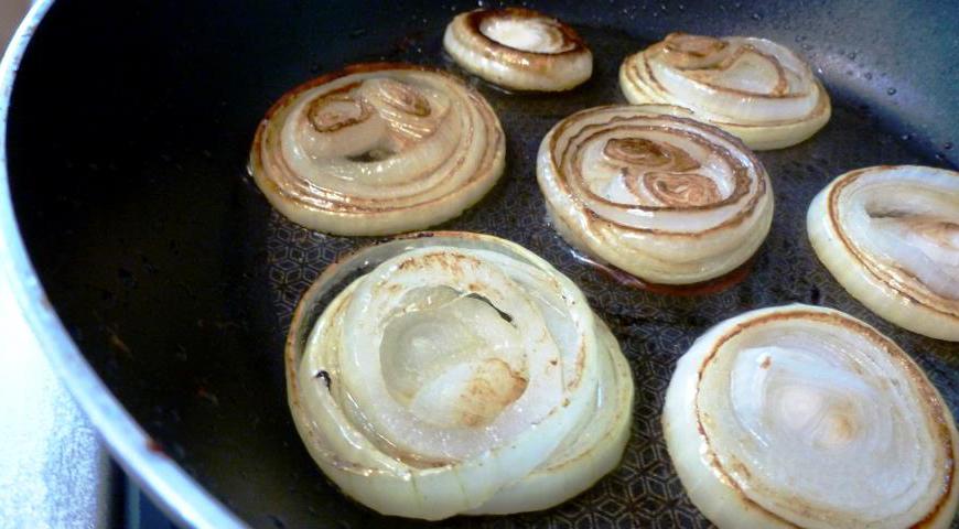 Лук нарежем тонкими полукольцами и обжарим на среднем огне до красивого золотистого цвета. Это добавит бургеру сладковатый аромат и хрустящую текстуру.