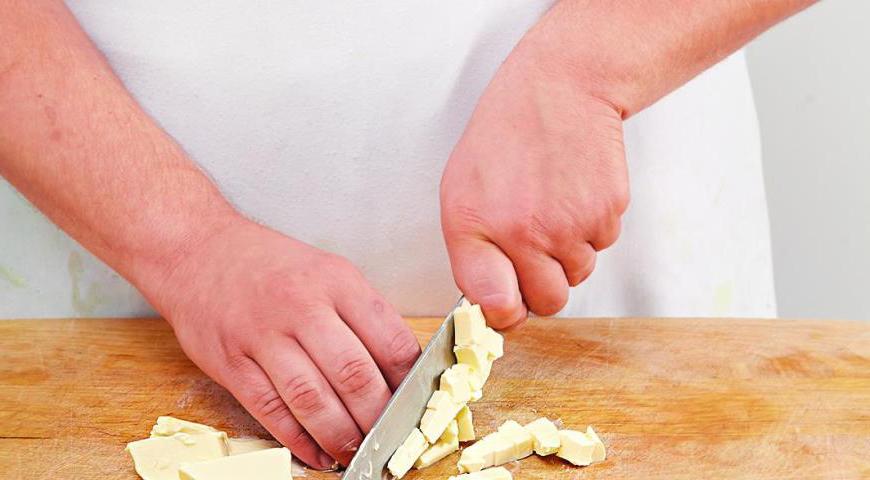 Холодное сливочное масло нарежьте небольшими кубиками. Муку просейте на рабочую поверхность, добавьте масло и рубите ножом до получения рассыпчатой консистенции.