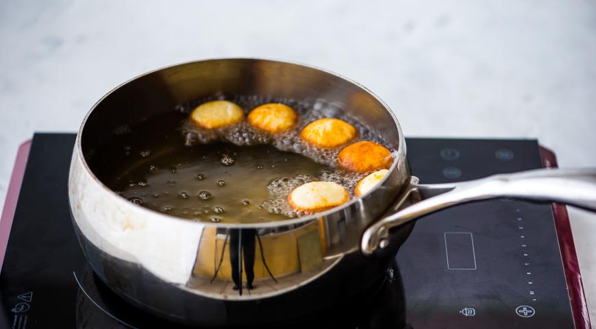 Налейте масло в глубокую сковороду или казан и разогрейте до 180 °C. Обжарьте шляпки и ножки порциями до золотистого цвета. После остывания сделайте небольшое углубление на одной стороне шляпок для последующего крепления ножки.