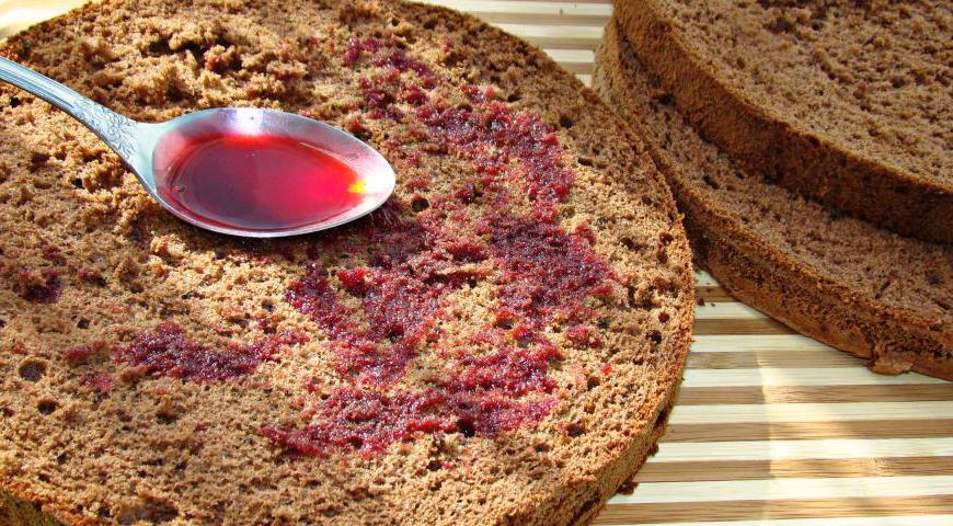 Готовый бисквит аккуратно разрежьте на три коржа и каждый пропитайте вишневым сиропом для большей сочности.