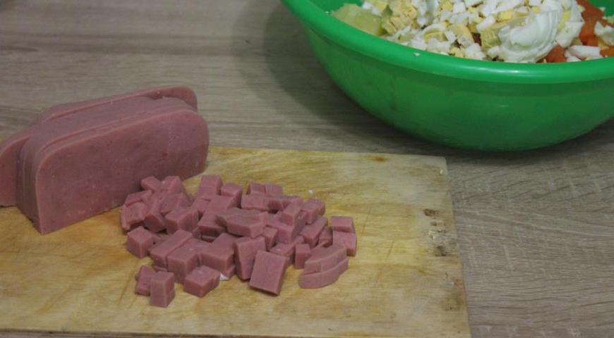 Яйца также нарезать кубиками, можно воспользоваться яйцерезкой для удобства. Ветчину нарезать аналогично.