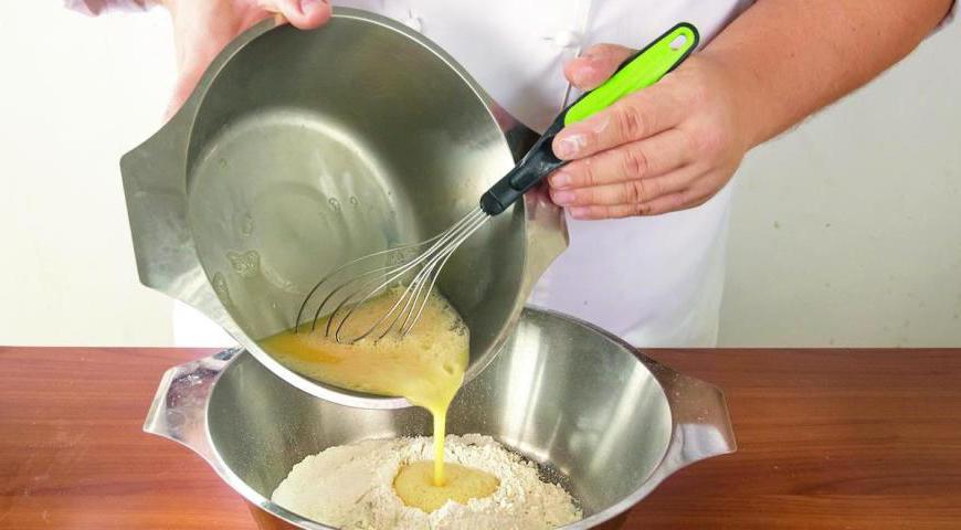 В большую миску просейте муку вместе с солью и дрожжами, добавьте сахар и тщательно перемешайте. В отдельной емкости взбейте три яйца до однородности и вылейте их в центр муки. Постепенно замешивайте мягкое эластичное тесто.