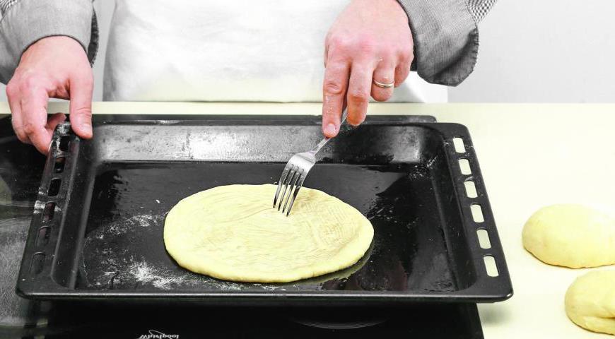 Разогрейте духовку до 210 °C. Выложите заготовки на противень, предварительно смазанный маслом, сделайте несколько проколов вилкой и проделайте небольшое отверстие в центре каждой лепешки. Выпекайте около 25 минут или до золотистого цвета. Готовые хачапури накройте полотенцем и оставьте на 10 минут перед подачей.