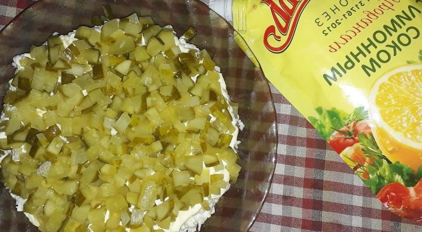 Четвертый слой — маринованные огурцы, нарезанные мелкими кубиками.