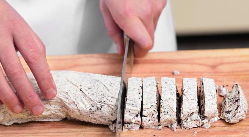 После того как мороженое затвердеет, аккуратно разверните его. Приготовьте емкость с горячей водой, чтобы окунать нож перед каждым разрезом — это позволит получить ровные диски. Нарежьте массу на 10 одинаковых кружков.