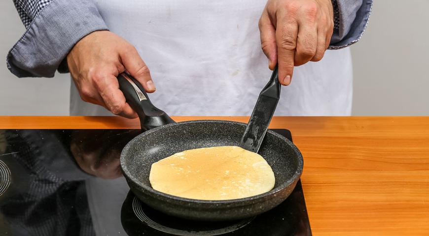 На хорошо разогретой сухой сковороде выпекайте крупные панкейки с обеих сторон до золотистого цвета. Каждый готовый блин сразу смазывайте теплым сгущенным молоком для дополнительной сочности.