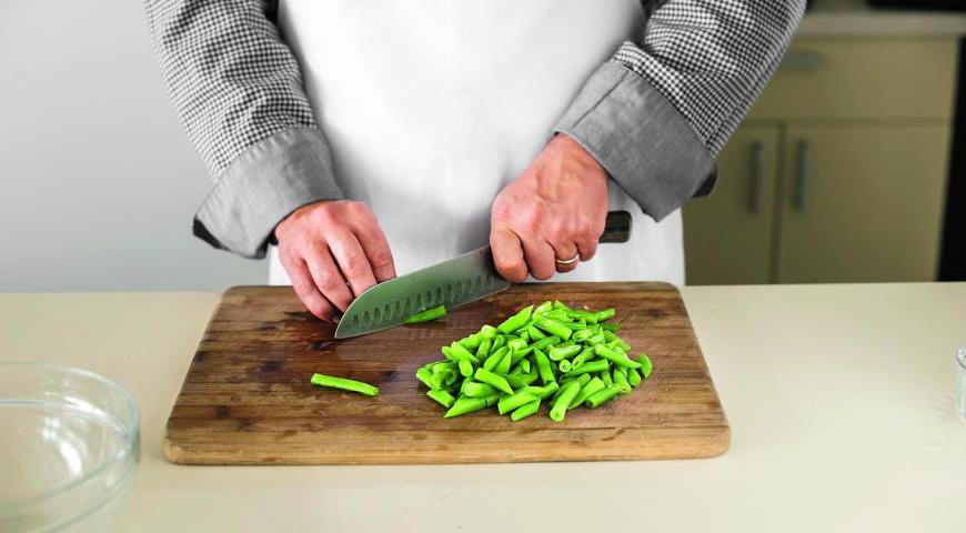 Нарежьте стручковую фасоль диагональными кусочками длиной 2,5 см и перемешайте её с уже приготовленной фасолью.