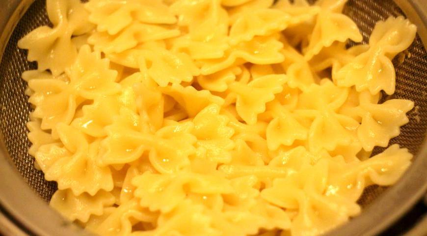 Макароны типа «мини фарфалле» отварите согласно инструкции на упаковке, затем откиньте на дуршлаг, промойте холодной водой и дайте немного остыть. После этого сложите все компоненты — курицу, апельсиновые кусочки, грибы и макароны — в глубокий салатник, добавьте маринованную морковь.
