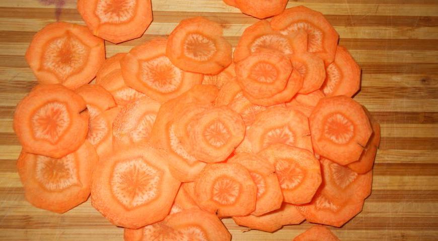 Очистите морковь и нарежьте её очень тонкими кружочками. Поместите их в холодную подсоленную воду на 20 минут, чтобы сделать более мягкими и эластичными для последующего формирования цветов.